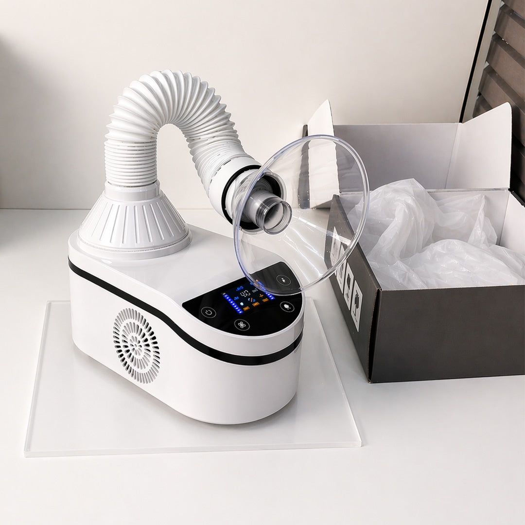 White electronic device with hose and clear container on a white surface