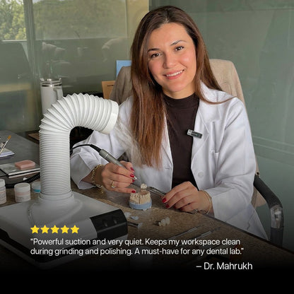 Woman in a dental lab setting with dental equipment, smiling at the camera.