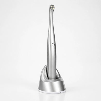 Cordless intraoral dental camera with LED lighting on charging base.