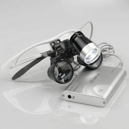 silver dental binoculars with clip-on LED headlight and battery