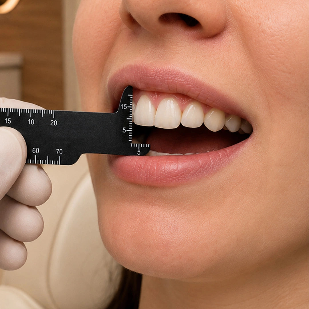 Dentist using tooth measuring gauge to measure patient front teeth.