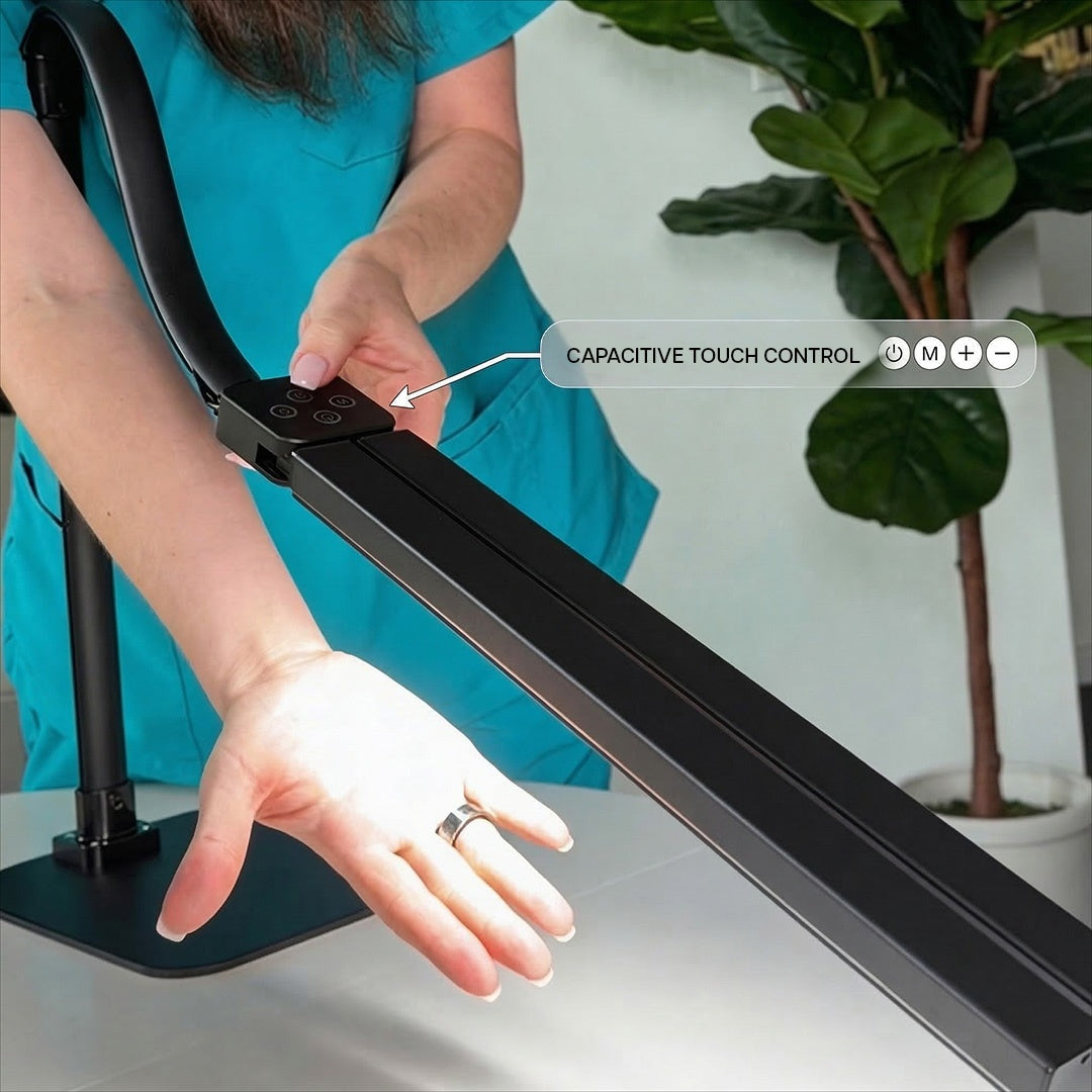 Person using a capacitive touch control on a modern desk with a plant in the background